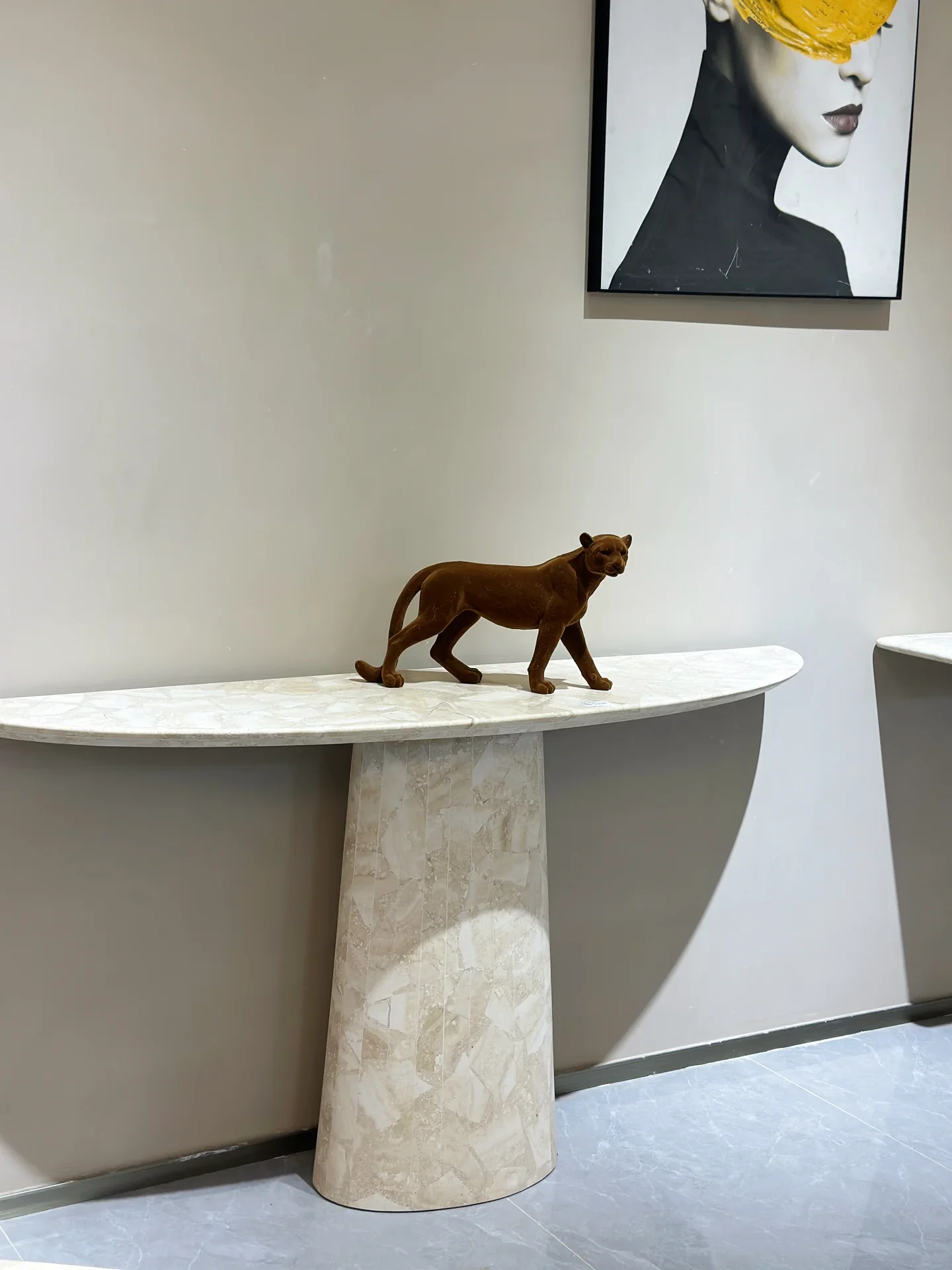 A semicircular pale stone console with a cylindrical pedestal