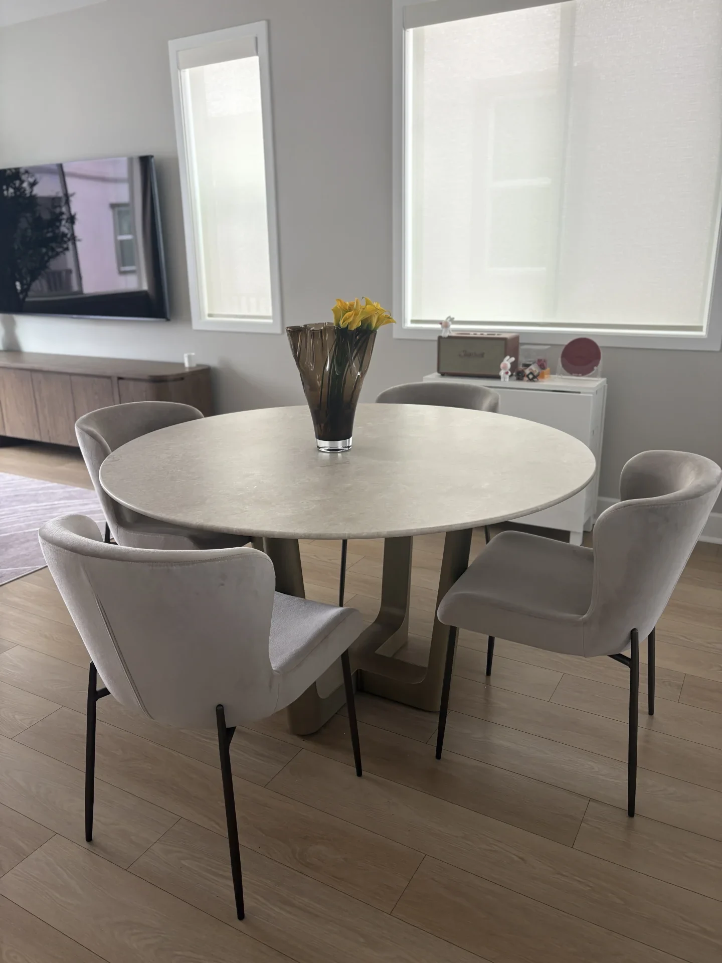 A round pale stone dining table with upholstered chairs
