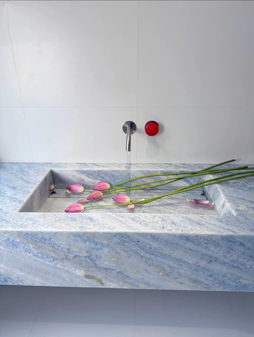 A blue-grey integrated stone basin with flowers