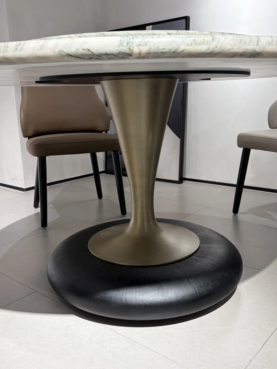 A metal pedestal supporting a veined stone tabletop