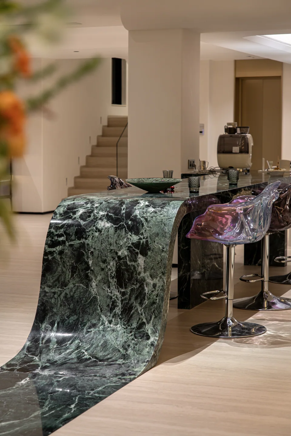 A green stone counter flowing from tabletop to floor