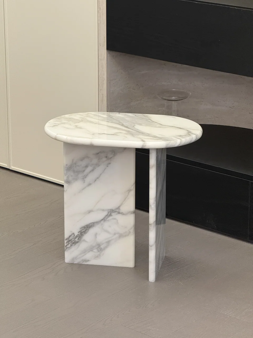 Round white marble side table in a neutral room
