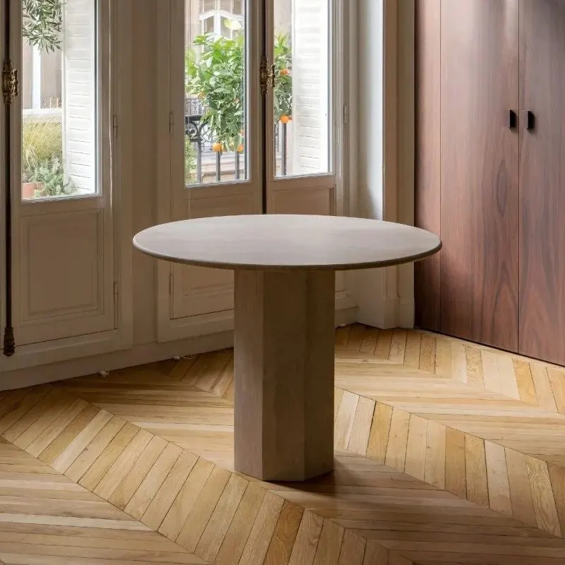 Round travertine dining table on a drum base
